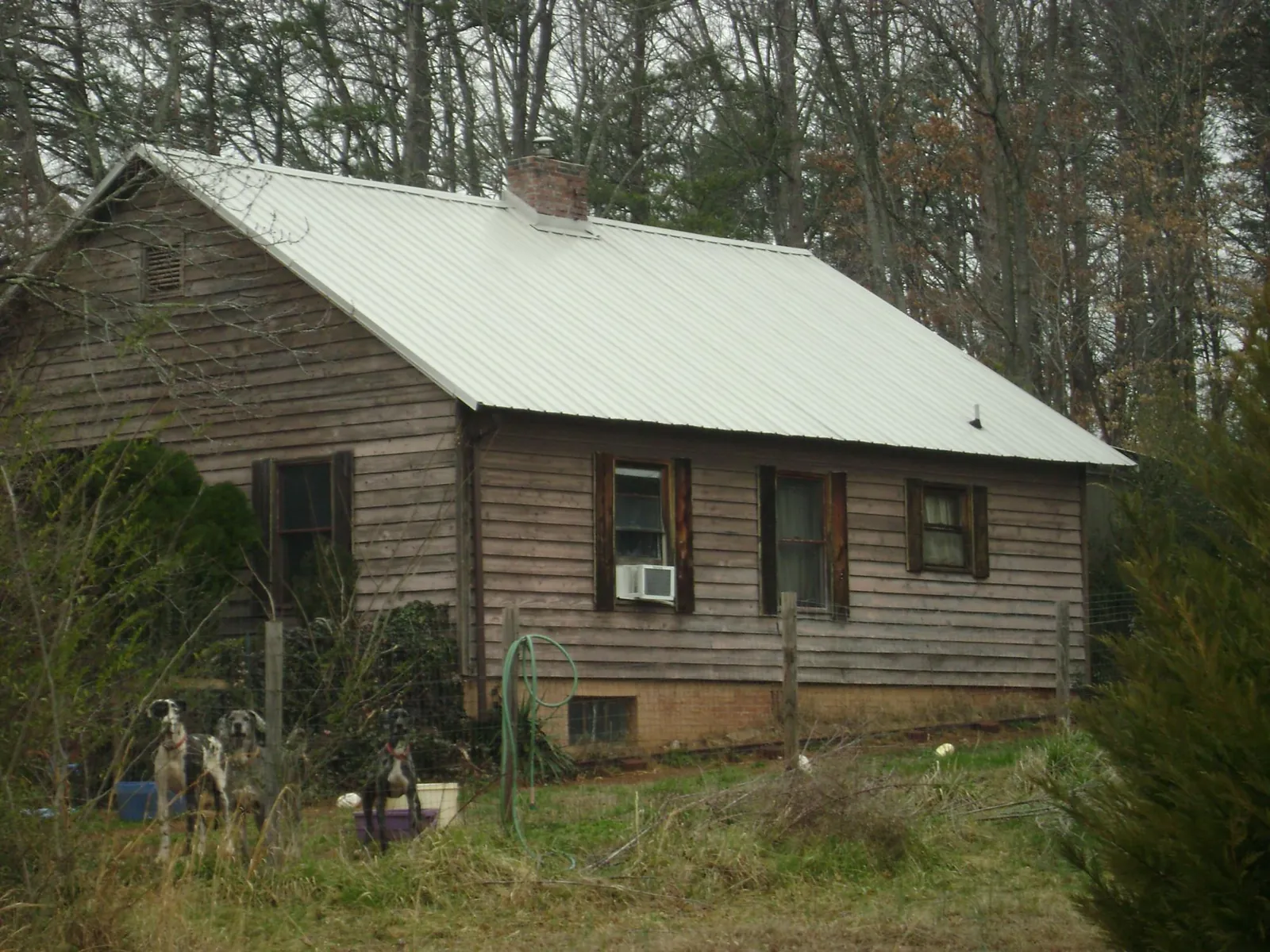 White metal roof on an old wood sided farmhouse, from a Metal Roof Installation job in Aiea